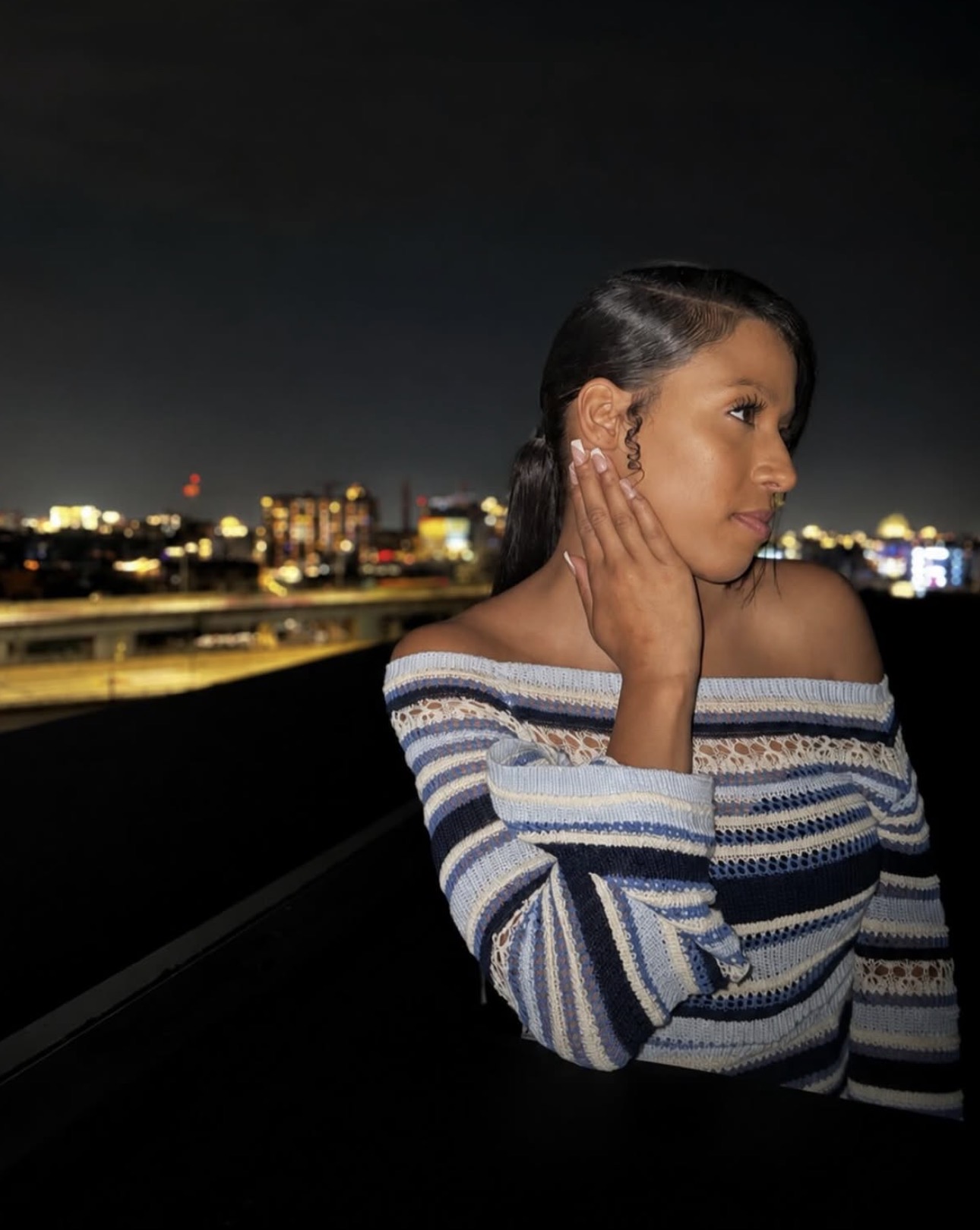 Jasmine Welch, founder of JazzyJ Photography, on a rooftop at night